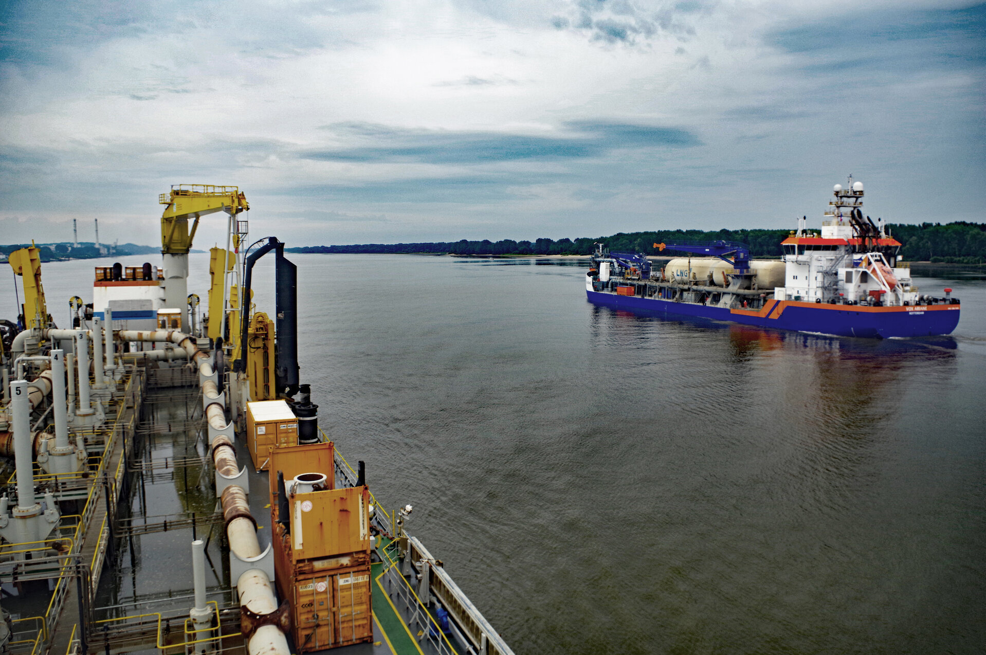 Blick über das Deck eines Hopperbaggers auf der Elbe bei Wedel, daneben ein weiterer Hopperbagger