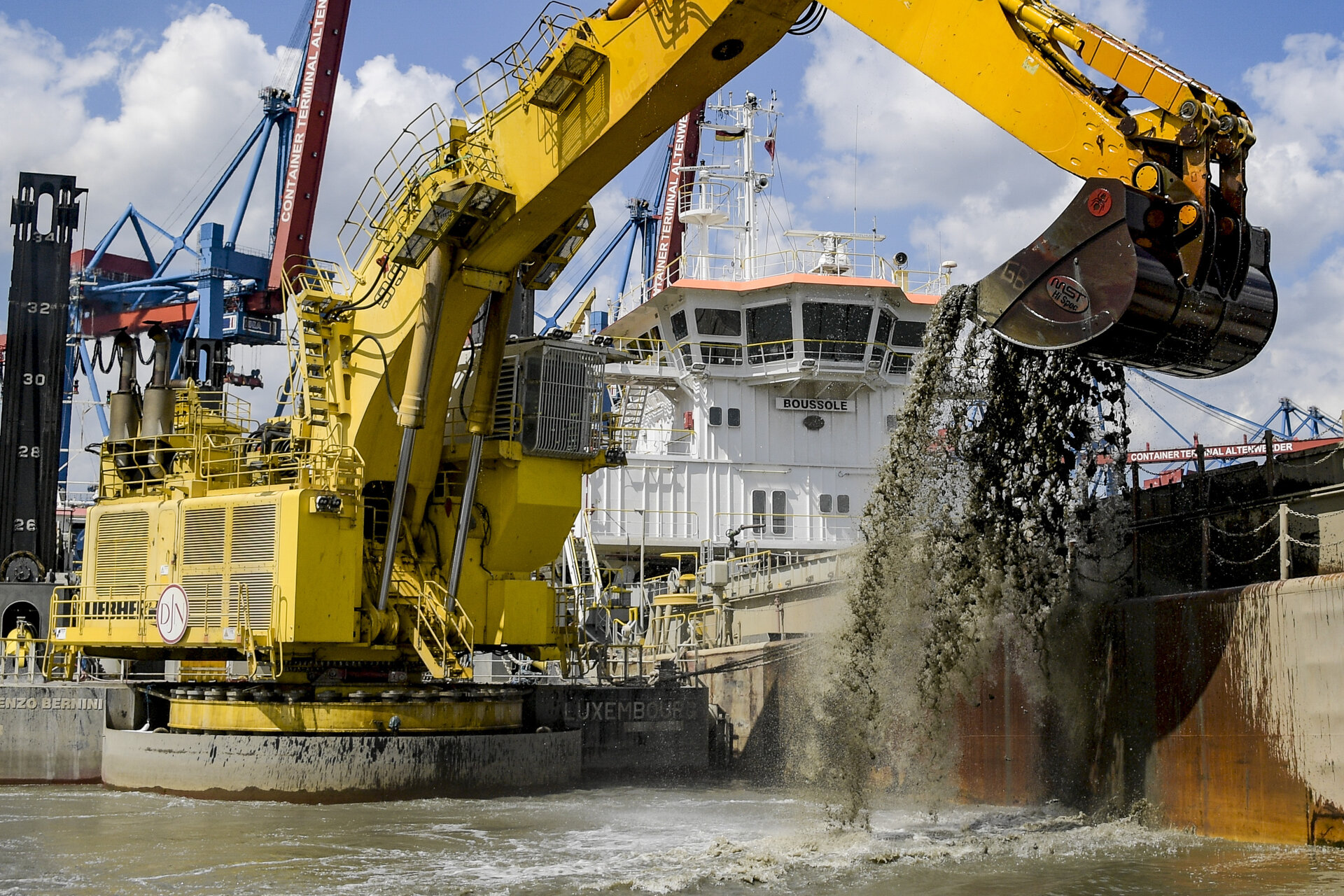 Der schwimmende Greiferbagger Lorenzo Bernini lädt Elbesedimente in das Transportschiff Boussole